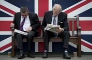 Racegoers are seen looking at the form guide during Ladies Day, the first day of the Epsom Derby horse racing event